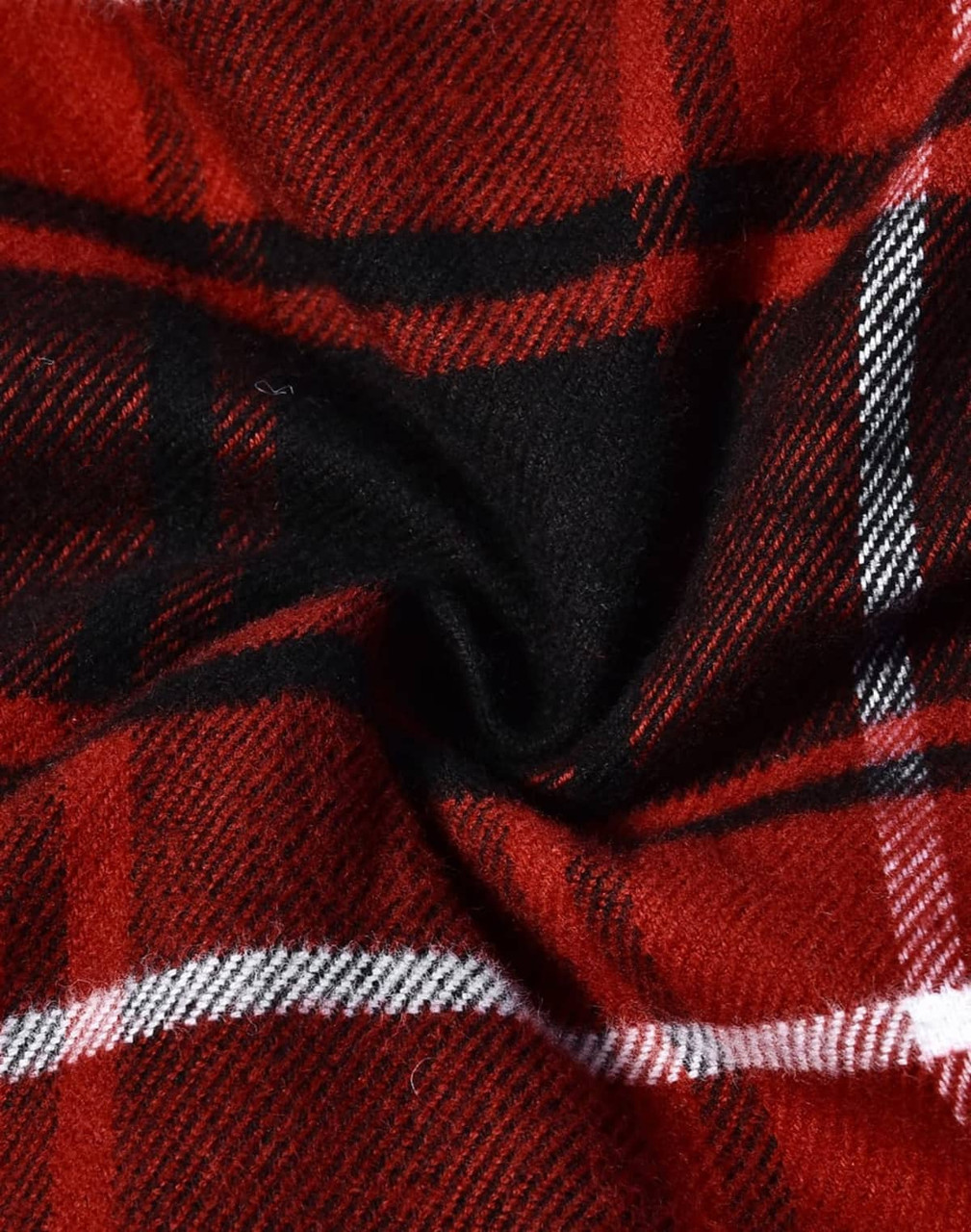 A close-up of red and black plaid flannel fabric with white stripes, showcasing a soft, quilted texture.