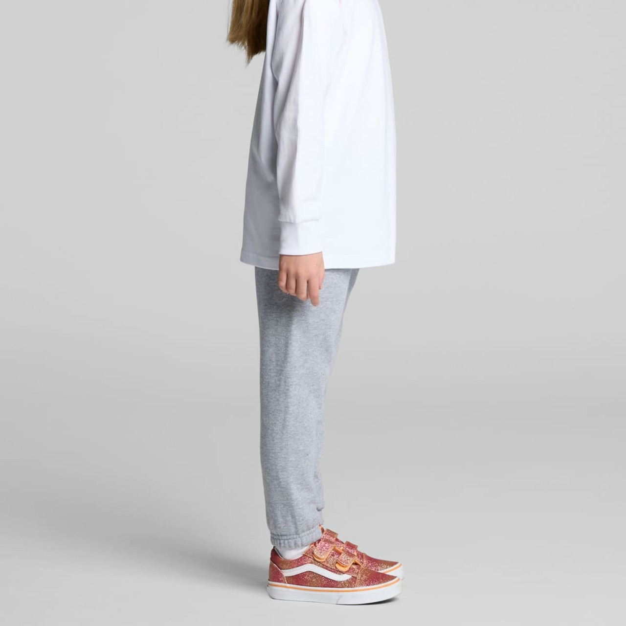 Grey track pants for kids, featuring an elasticated waistband and a relaxed fit, paired with stylish shoes.