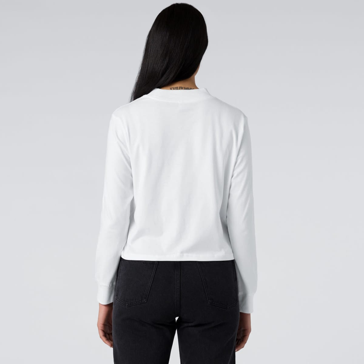 A white long-sleeve tee displayed from the back, featuring a logo on the neckline.