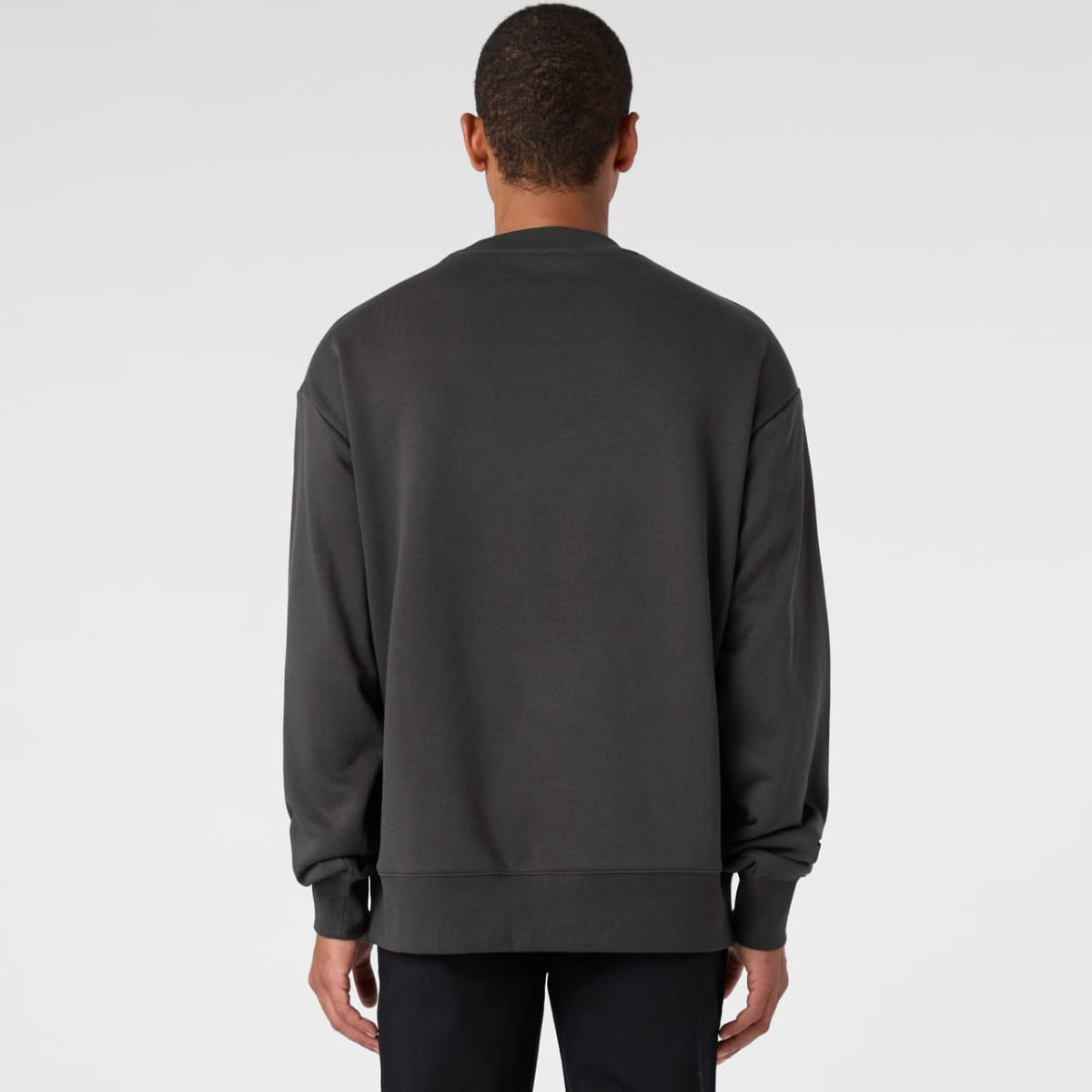 A grey jumper with long sleeves and a relaxed fit, featuring a logo on the back.
