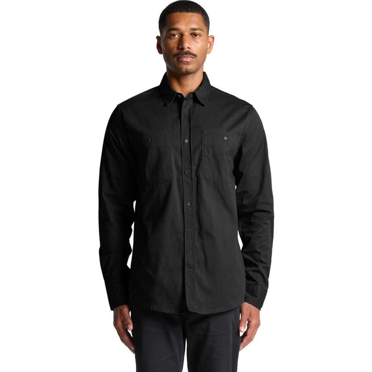 A black work shirt featuring long sleeves and two chest pockets, worn by a model. It includes a logo.