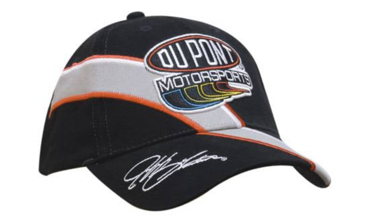 A black cap featuring embroidered trim and inserts, with a logo and signature detail on the front.