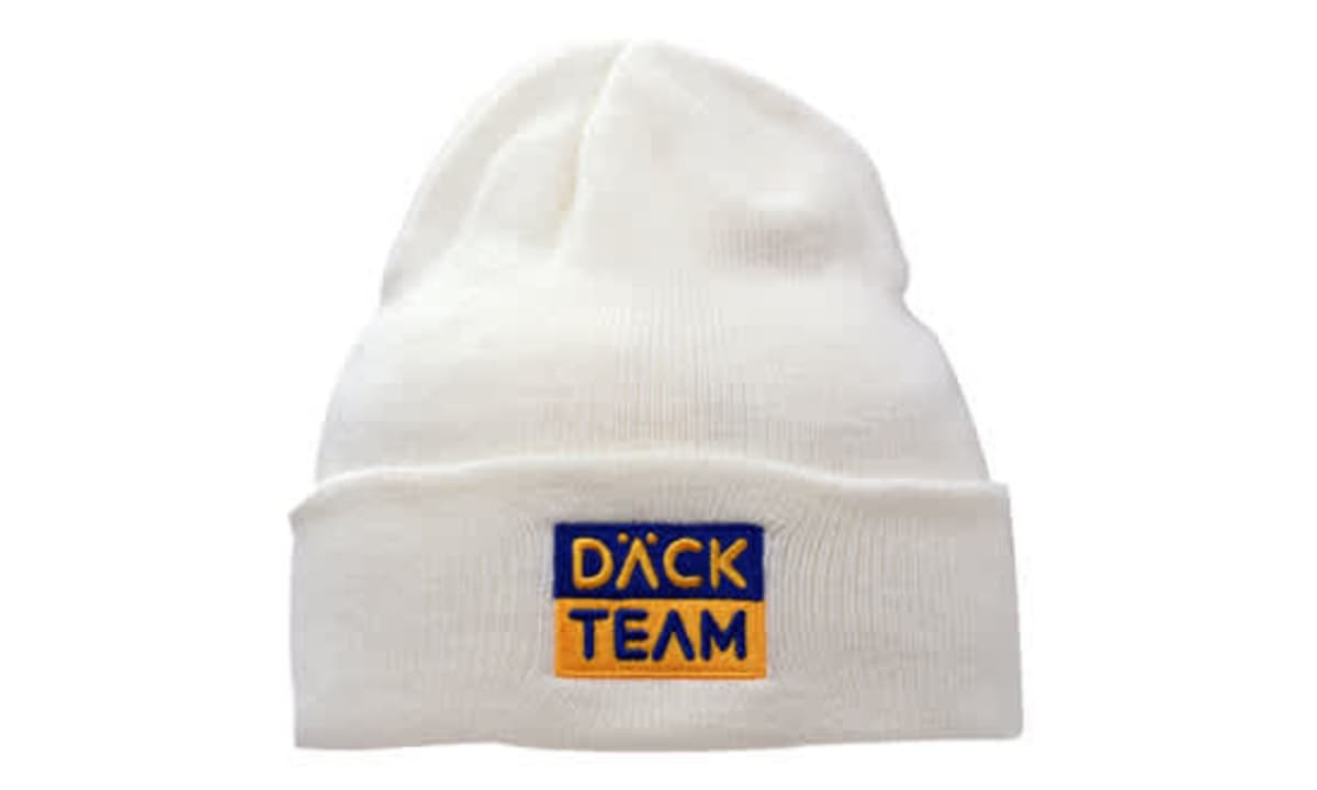 A white acrylic beanie with a folded cuff, featuring an embroidered logo in blue and yellow.