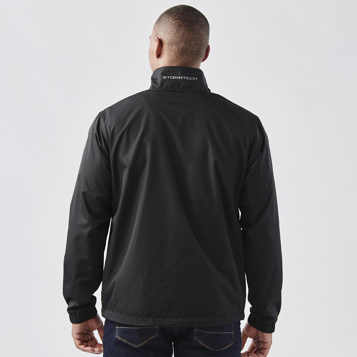 A black jacket with a high collar and branding on the back, featuring a simple and sleek design.