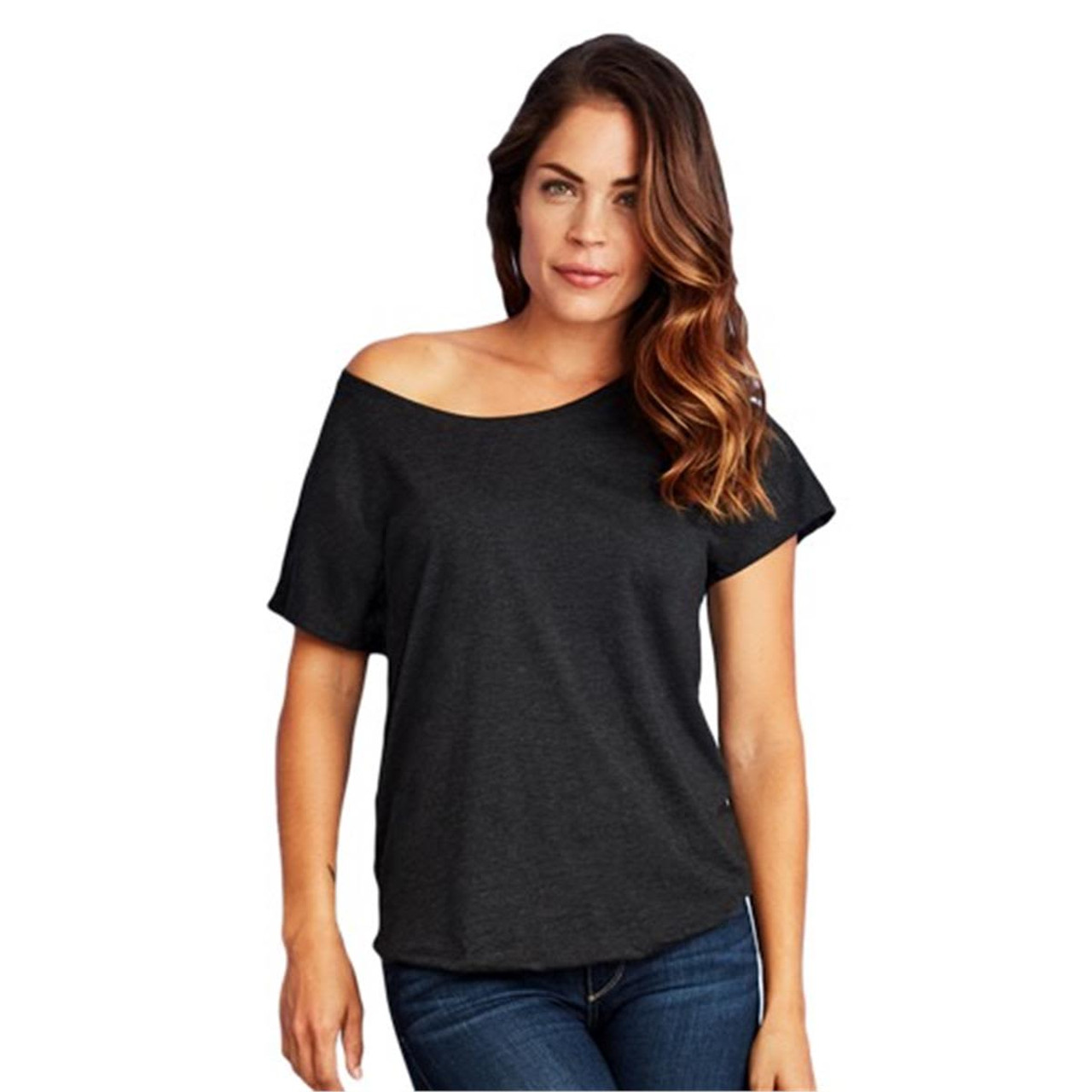 A woman is wearing a black tri-blend dolman t-shirt, featuring a relaxed fit and an off-shoulder design.