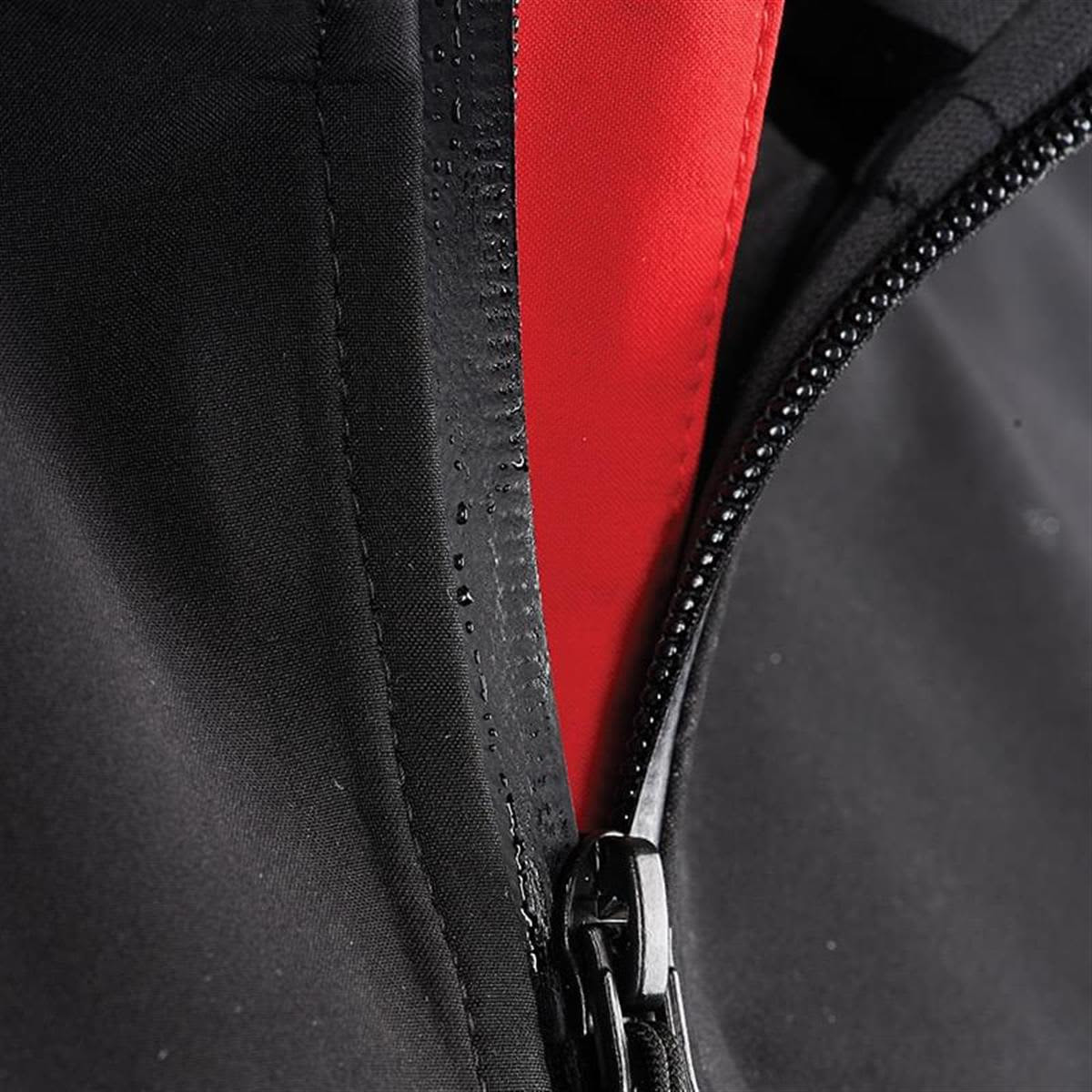 A close-up of a black softshell jacket featuring a red interior and a zippered front. The jacket has a logo.