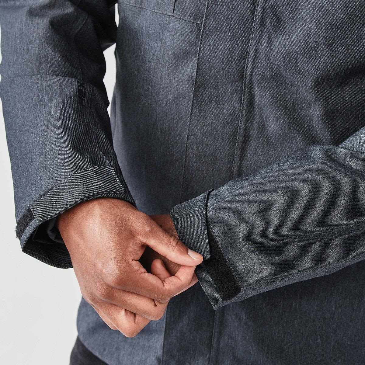 A close-up of a men's jacket featuring a dark grey colour with a textured fabric and adjustable cuffs.