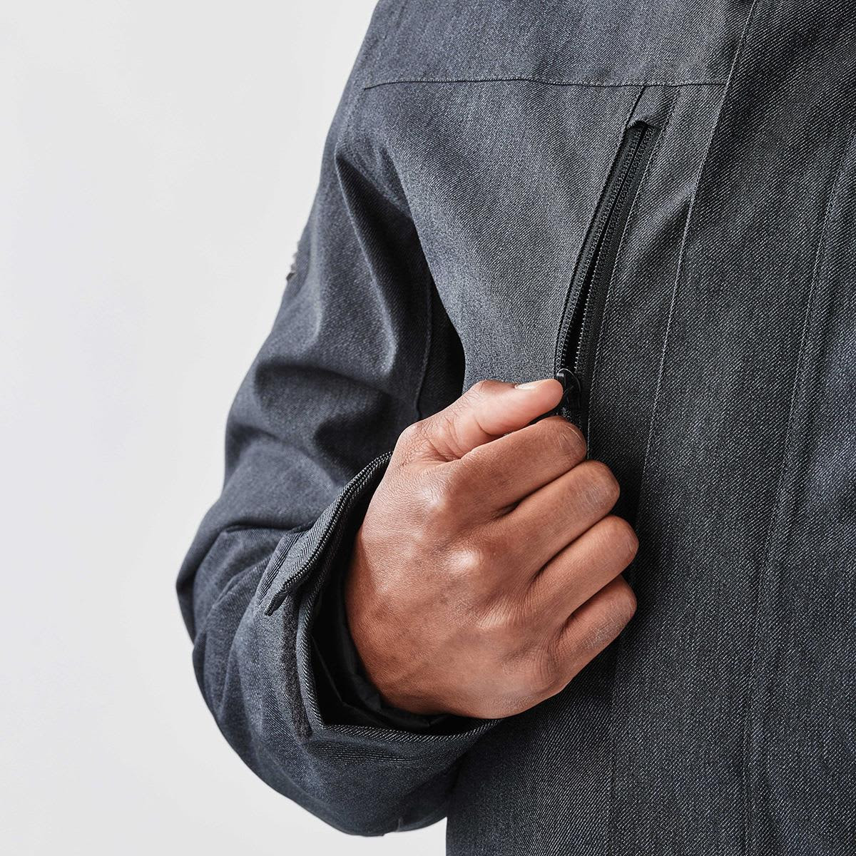 A men's jacket in dark grey with a zippered pocket and cuff detail, featuring a logo on the sleeve.