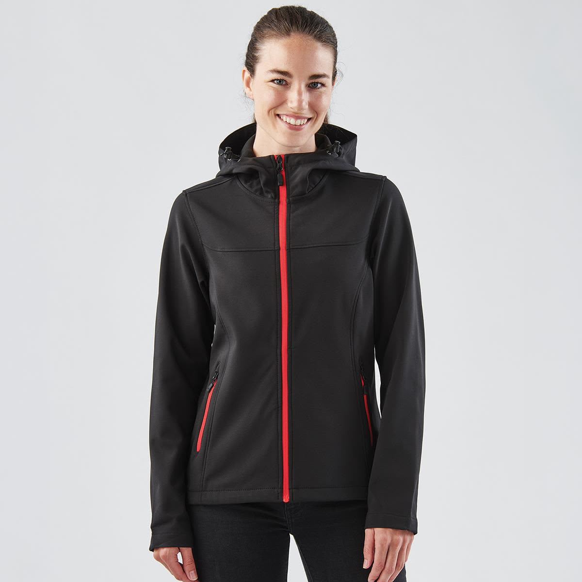 A black women's softshell hoody featuring red zip accents and a hood, with a logo on the chest.