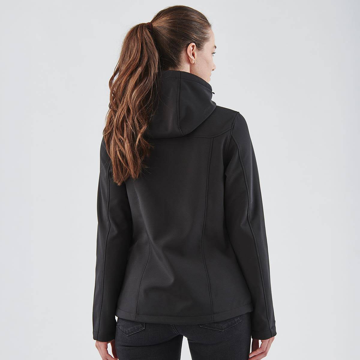 A black women's softshell hoody with a hood, viewed from the back, featuring a fitted design.