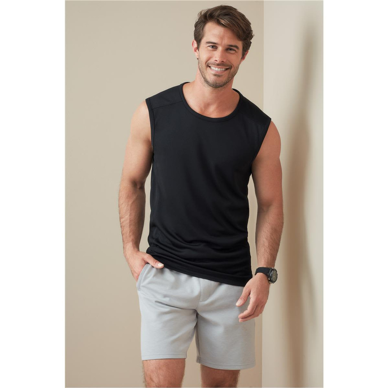 A sleeveless black active shirt displayed on a model, paired with grey shorts, featuring a logo on the shirt. A sleeveless black active shirt displayed on a model, paired with grey shorts, featuring a logo on the shirt.