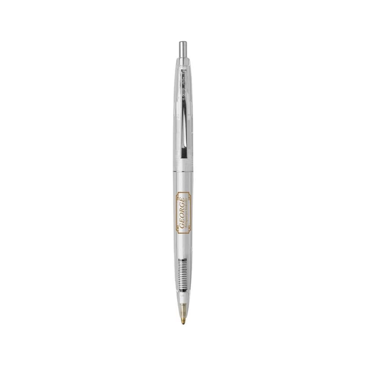 A clear plastic pen with a gold trim and a click mechanism, featuring a logo on the barrel.