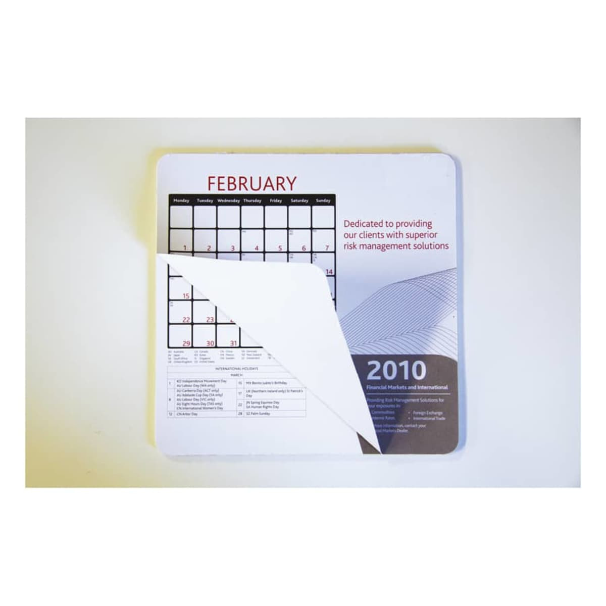 A mouse mat featuring a calendar design for February 2010, primarily in white with red and grey accents.