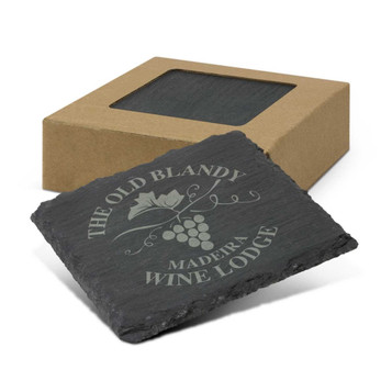 A set of four black slate coasters inside a cardboard box, featuring a grapevine design and a logo. A set of four black slate coasters inside a cardboard box, featuring a grapevine design and a logo.