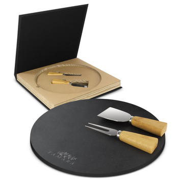 A round black slate cheese board with two wooden-handled knives, displayed in a black box. A round black slate cheese board with two wooden-handled knives, displayed in a black box.