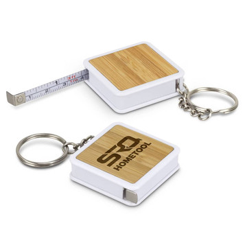 A bamboo tape measure key ring with a white casing and a silver key ring attachment. Features a measuring tape inside. A bamboo tape measure key ring with a white casing and a silver key ring attachment. Features a measuring tape inside.