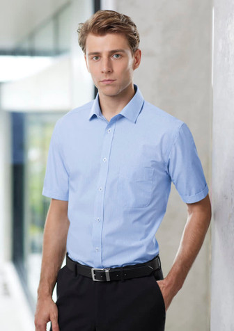 A light blue short sleeve button-up shirt on a model, featuring a chest pocket and a logo. A light blue short sleeve button-up shirt on a model, featuring a chest pocket and a logo.