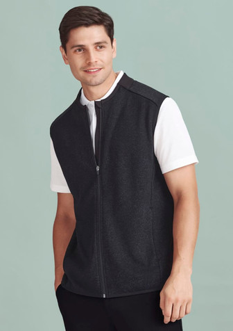 A men's black zip-front vest over a white shirt. The vest features a logo on the chest. A men's black zip-front vest over a white shirt. The vest features a logo on the chest.