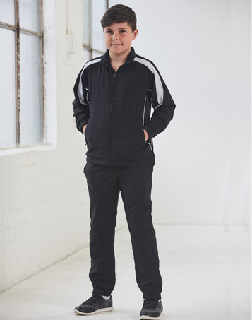 A black kids' warm-up jacket with white accents, paired with matching black pants. The model stands with hands in pockets.