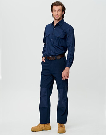 A man wearing beige work pants featuring pockets and reinforced knee patches, paired with a matching long-sleeve shirt.