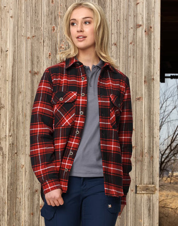 A quilted flannel shirt in red and black check design, featuring buttons and front pockets, worn by a model outdoors.