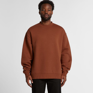 A man wearing a brown sweatshirt with a relaxed fit, featuring long sleeves and a round neckline. A man wearing a brown sweatshirt with a relaxed fit, featuring long sleeves and a round neckline.