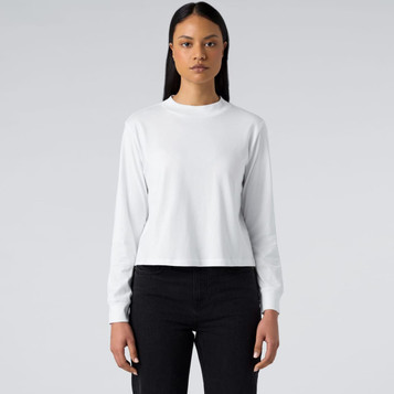 A white long sleeve tee, featuring a round neckline and a fitted design, worn with dark jeans.