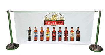 A crowd barrier featuring a white banner with various beer bottles displayed, supported by green metal poles and bases. A crowd barrier featuring a white banner with various beer bottles displayed, supported by green metal poles and bases.