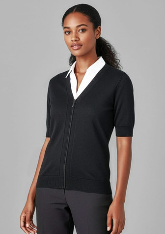 A fitted black short sleeve cardigan featuring a zip front, styled with a white shirt underneath.