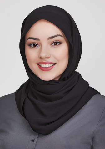 A black women's hijab worn by a smiling woman, featuring a smooth fabric and a simple style.