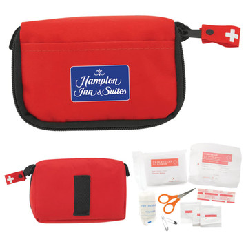 A red first aid kit with a logo, containing scissors, bandages, antiseptic wipes, and various medical supplies. A red first aid kit with a logo, containing scissors, bandages, antiseptic wipes, and various medical supplies.