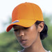 An orange cap on a person, featuring a logo on the front, set against a blurred outdoor background. An orange cap on a person, featuring a logo on the front, set against a blurred outdoor background.