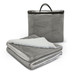 A grey luxury blanket with a soft white underside, folded and placed next to a zipped storage bag.