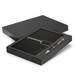 A black notebook with a green band and a silver pen, presented in a black gift box. A black notebook with a green band and a silver pen, presented in a black gift box.