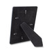 A black photo frame with a standing support and back clips for securing photos, featuring a logo on the back. A black photo frame with a standing support and back clips for securing photos, featuring a logo on the back.