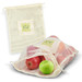 A cotton produce bag filled with red and green apples, featuring a logo that reads "Organic." A cotton produce bag filled with red and green apples, featuring a logo that reads "Organic."