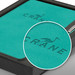 A teal notebook with a textured finish and a silver pen, presented in a black gift box featuring a logo. A teal notebook with a textured finish and a silver pen, presented in a black gift box featuring a logo.