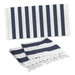 A striped Okana cotton towel in navy blue and white, featuring fringed edges, displayed flat and folded.