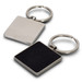 A square key ring featuring a silver metal finish with a textured black surface on one side and a smooth silver back.