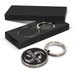 A round silver key ring with a black, textured surface, presented in a sleek black box.