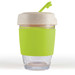 A reusable coffee cup with a clear glass base, a green silicone band, and a speckled lid with a straw. A reusable coffee cup with a clear glass base, a green silicone band, and a speckled lid with a straw.