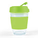 A reusable coffee cup with a transparent body and a bright green lid and sleeve. It has a logo present. A reusable coffee cup with a transparent body and a bright green lid and sleeve. It has a logo present.