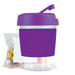 A purple reusable coffee cup with a lid and a clear bottom, accompanied by a pack of jelly beans. A purple reusable coffee cup with a lid and a clear bottom, accompanied by a pack of jelly beans.