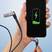 A charging cable with a dark blue fabric finish, connected to a smartphone displaying a battery icon. A charging cable with a dark blue fabric finish, connected to a smartphone displaying a battery icon.