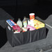 A black cargo storage organizer filled with various drinks and snacks, set against a dark background. A black cargo storage organizer filled with various drinks and snacks, set against a dark background.
