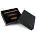 A black gift box containing an orange pen, a black USB drive, and a stylish black card holder. A black gift box containing an orange pen, a black USB drive, and a stylish black card holder.