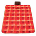 A red and black checkered picnic blanket features a handle for easy carrying and a logo in one corner. A red and black checkered picnic blanket features a handle for easy carrying and a logo in one corner.