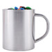 A stainless steel mug filled with colorful M&M's candies.