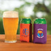 A drink cooler in orange and purple holds cans, with a beer glass nearby. Both coolers feature different logos. A drink cooler in orange and purple holds cans, with a beer glass nearby. Both coolers feature different logos.
