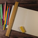 A 30cm bamboo ruler rests on an open notebook alongside various colored pens and a yellow eraser.